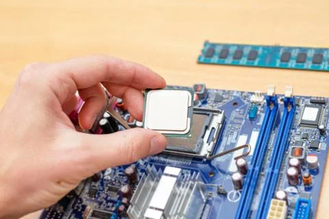 Computer processor installation into motherboard socket. Close-up. Work desk. 写真素材