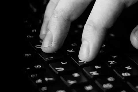 Computer programmer and hacker hands typing laptop keyboard, close up low key Stock Photos
