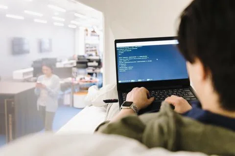 Computer programmer coding at laptop in office 写真素材