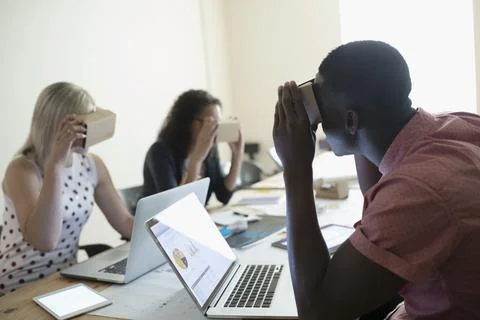 Computer programmer designers testing virtual reality simulator glasses at lapto Stock Photos