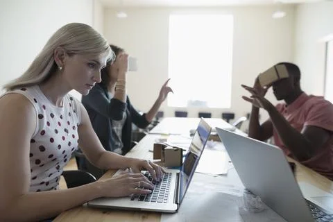 Computer programmer designers testing virtual reality simulator glasses at lapto Stock-Fotos