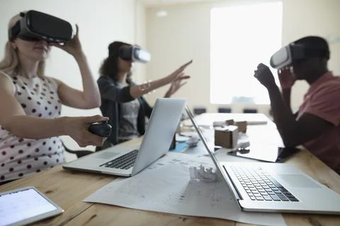 Computer programmer designers testing virtual reality simulator glasses at lapto Stock-Fotos