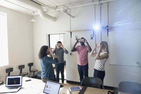Computer programmer designers testing virtual reality simulator glasses in confe 스톡 사진