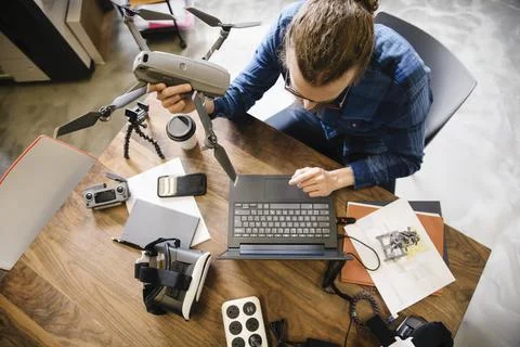 Computer programmer with drone working at laptop in office Stock Photos