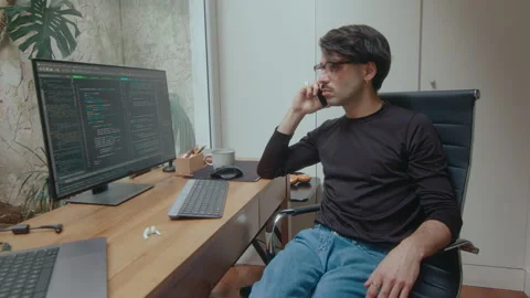 Computer Programmer Having Phone Conversation at Workplace Stock Footage 252751423