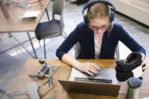 Computer programmer with headphones and virtual reality simulator glasses workin Stockfoto's