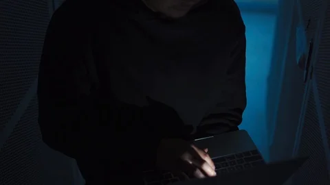 A computer programmer or hacker prints a code on a laptop keyboard to break i Stock Footage 121612469