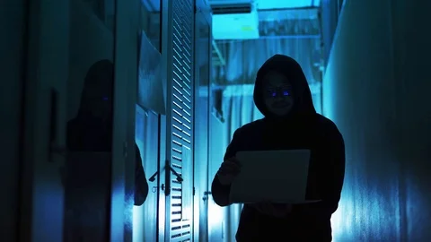 A computer programmer or hacker prints a code on a laptop keyboard to break i Stock Footage 121612474