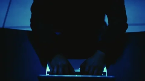 A computer programmer or hacker prints a code on a laptop keyboard to break i Stock Footage 138948951