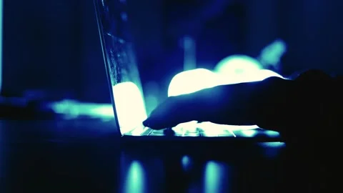A computer programmer or hacker prints a code on a laptop keyboard to break i Stock Footage 138949355