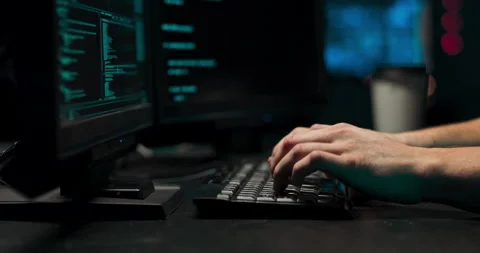 A computer programmer or hacker prints a code on a laptop keyboard to break into Stock Footage 146087562