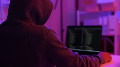 A computer programmer or hacker prints a code on a laptop keyboard to break into Video stock 325556366