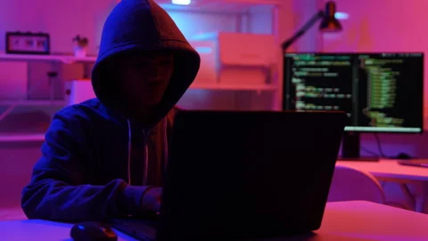 A computer programmer or hacker prints a code on a laptop keyboard to break into Video stock 325556494