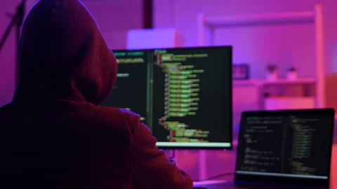 A computer programmer or hacker prints a code on a laptop keyboard to break into Video stock 325556682