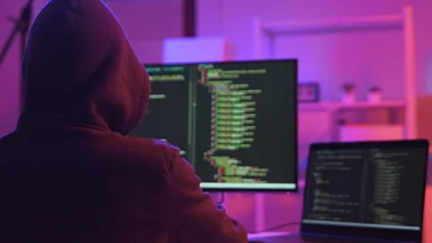 A computer programmer or hacker prints a code on a laptop keyboard to break into Video stock 327387981