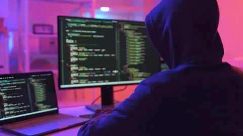 A computer programmer or hacker prints a code on a laptop keyboard to break into Video stock 327388117