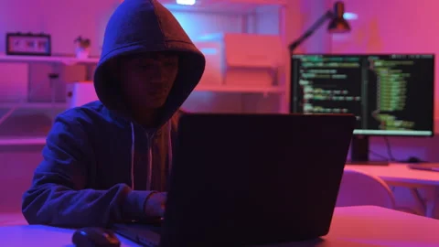 A computer programmer or hacker prints a code on a laptop keyboard to break into Video stock 327388150