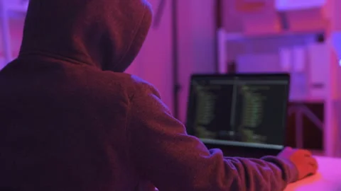 A computer programmer or hacker prints a code on a laptop keyboard to break into Video stock 327388278