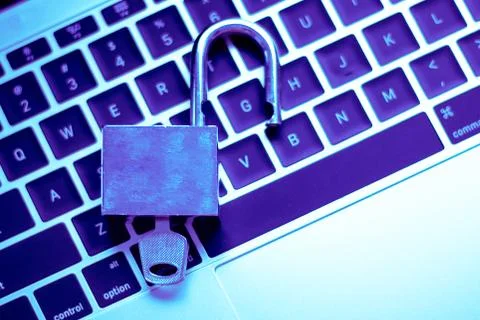 A computer programmer or hacker prints a code on a laptop keyboard to break i Foto stock