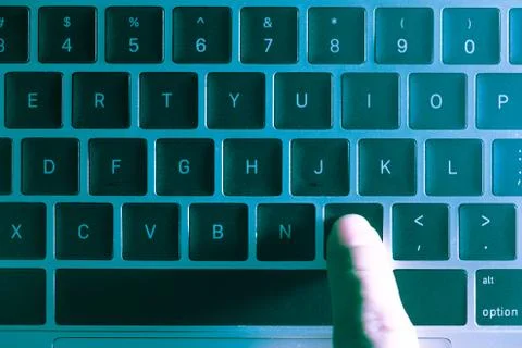 A computer programmer or hacker prints a code on a laptop keyboard to break i 写真素材