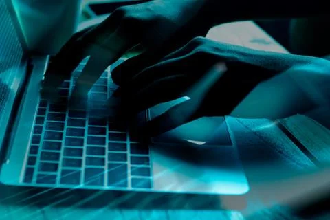 A computer programmer or hacker prints a code on a laptop keyboard to break i 写真素材