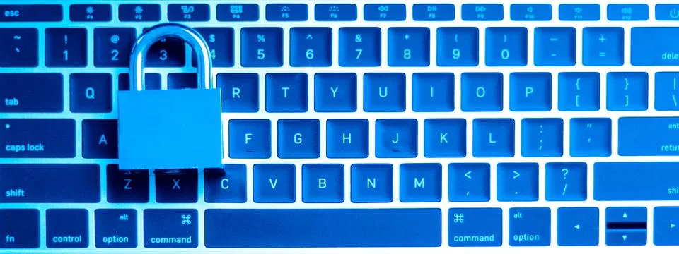 A computer programmer or hacker prints a code on a laptop keyboard to break i Stock Photos