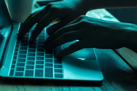 A computer programmer or hacker prints a code on a laptop keyboard to break i 写真素材