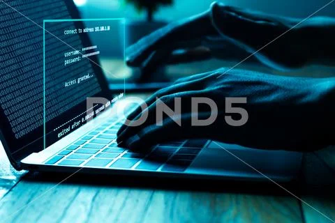 A computer programmer or hacker prints a code on a laptop keyboard to break i Stock Photos