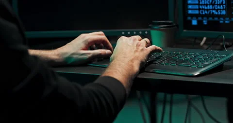 A computer programmer or hacker types a code on a computer keyboard to break Stock Footage 146092732