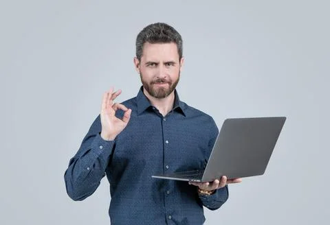 Computer programmer show ring gesture holding portable laptop grey background 스톡 사진