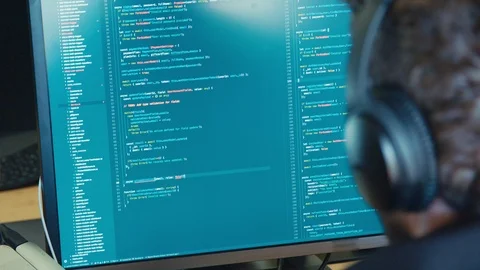Computer programmer sitting in front of a screen coding software Stock Footage 91938304