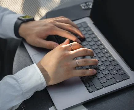 Computer programmer typing on laptop sitting at desktop Stock-Fotos