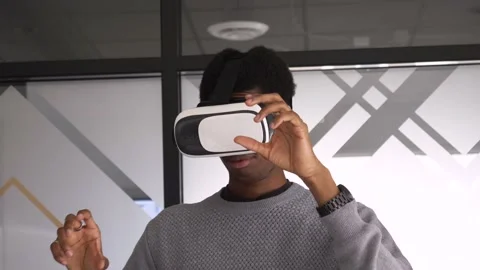 Computer programmer using virtual reality goggles in office Stock Footage 221041604