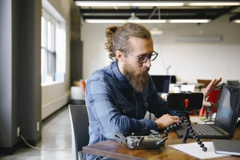 Computer programmer vlogging at laptop in coworking space 스톡 사진