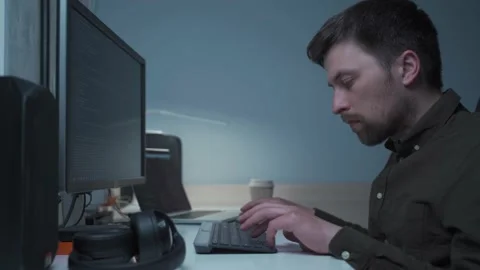 Computer programmer working at his desk at home. Male development specialist Stock Footage 153439081