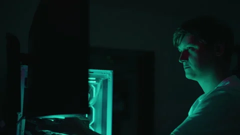 Computer programmer working late at night on desktop computer illuminated by Stock Footage 317535696