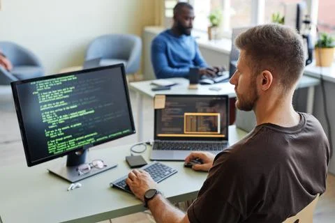Computer Programmer Writing Code in Office Stock Photos