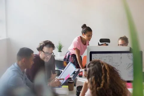 Computer programmers and designers working in open plan office Stock-Fotos