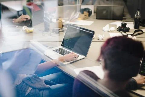 Computer programmers coding at laptops in conference room Stock Photos