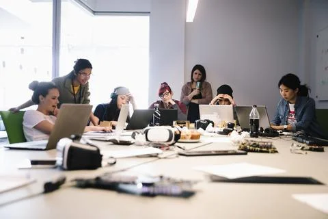 Computer programmers coding at laptops in conference room Foto stock