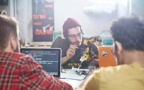 Computer programmers programming robotics in workshop Foto stock