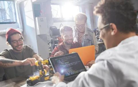 Computer programmers programming robotics in workshop 写真素材