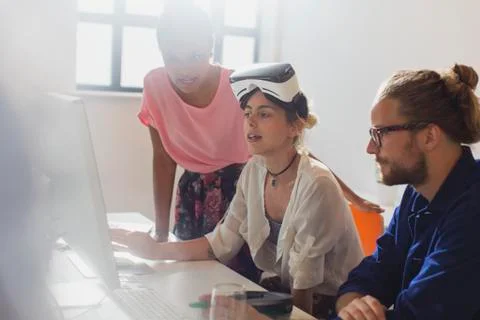 Computer programmers programming virtual reality simulator glasses at computer Stock Photos