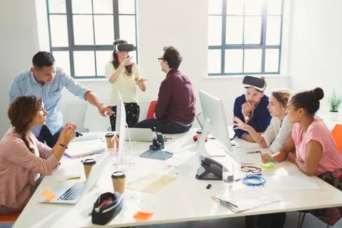 Computer programmers programming virtual reality simulator glasses in open plan Stock-Fotos