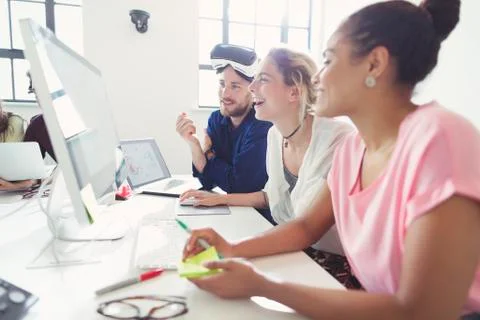 Computer programmers programming virtual reality simulator glasses in office Foto stock
