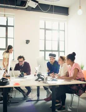 Computer programmers programming virtual reality simulator glasses in office Foto stock