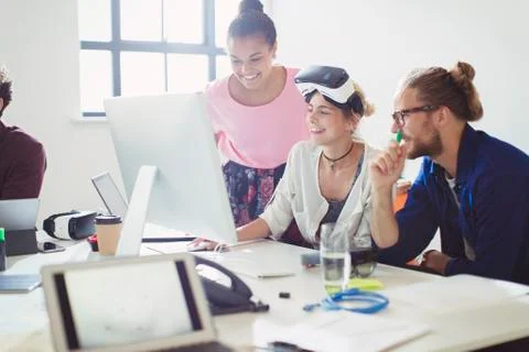 Computer programmers programming virtual reality simulator glasses at computer 스톡 사진