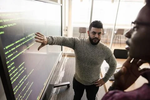 Computer programmers at projection screen in conference room Stock Photos