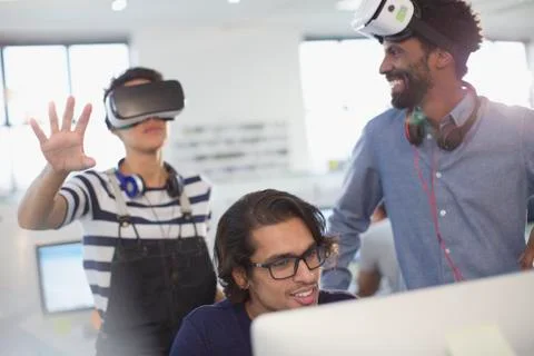 Computer programmers testing virtual reality simulator glasses in office Stock-Fotos