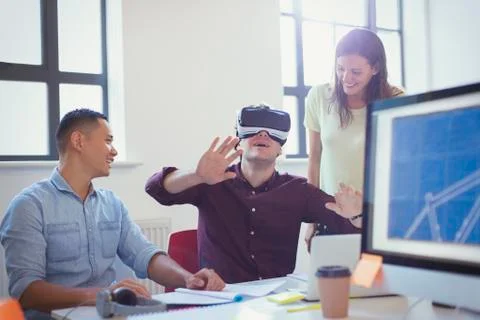 Computer programmers testing virtual reality simulator glasses in office Foto stock
